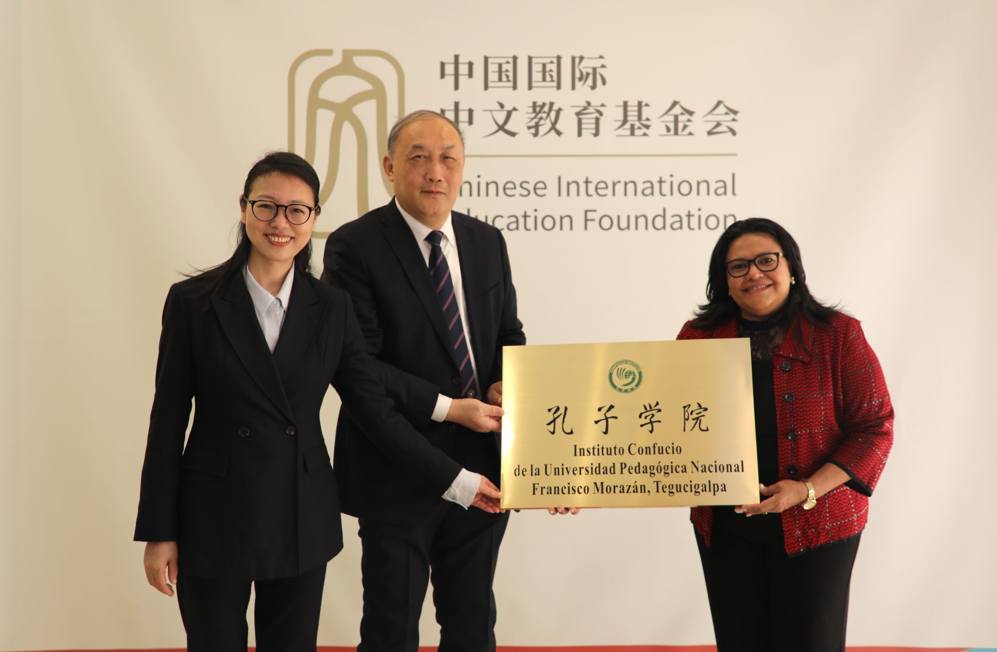 Representantes junto a una placa del Instituto Confucio de la Universidad Pedagógica Nacional Francisco Morazán durante una actividad en China.