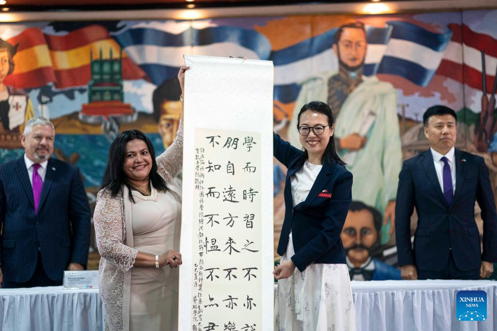 Autoridades sostienen una pieza de caligrafía china durante la inauguración del Instituto Confucio de la UPNFM en Tegucigalpa.